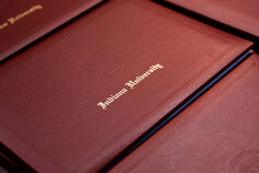 Indiana University diplomas sit in a stack.
